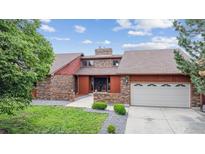 Charming brick home featuring a well-manicured lawn, mature trees, and an attached two car garage at 11254 E Colorado Dr, Aurora, CO 80012