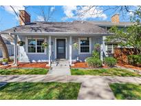Charming single-Gathering home showcasing beautiful curb appeal with well-manicured lawn, flower pots, and a cozy covered porch at 6960 S Knolls Way, Centennial, CO 80122