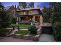 Elegant brick home featuring a landscaped front yard and wrought iron balcony at 1040 N Humboldt St, Denver, CO 80218