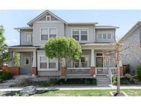 Charming gray two-story home featuring a welcoming front porch and well-maintained landscaping at 5450 Uinta St, Denver, CO 80238