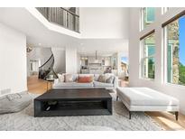 Bright, open-concept living room with a large picture window and stylish, neutral-toned furniture at 6635 Tremolite Dr, Castle Rock, CO 80108