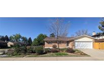 Charming brick home with a well-manicured front yard and attached two car garage at 12420 W Atlantic Ave, Lakewood, CO 80228
