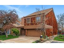 Charming two-story home featuring a two-car garage and unique wood shingle siding and landscaped front yard at 10102 W Ida Ave # 214, Littleton, CO 80127
