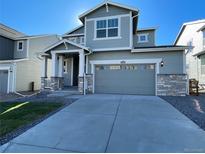 Two-story house with gray siding, attached garage, and landscaped lawn at 5598 Wisteria Ave, Firestone, CO 80504