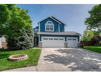 Charming two-story home with a three car garage, manicured lawn and a flower garden in the front yard at 901 Sage Sparrow Cir, Highlands Ranch, CO 80129