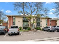 Two-story apartment building featuring balconies, a well-maintained parking lot, and mature trees at 12142 Melody Dr # 301, Denver, CO 80234