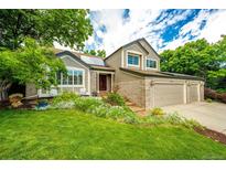 Charming two-story home featuring a well-manicured lawn and mature trees at 9301 Lark Sparrow Dr, Highlands Ranch, CO 80126