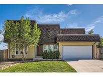 Charming two-story home with a well-manicured lawn and a two-car garage on a sunny day at 234 Cypress Cir, Broomfield, CO 80020