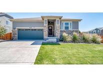 Charming home with a well-maintained lawn, complemented by a stone entryway and a two-car garage at 17028 Osage St, Broomfield, CO 80023