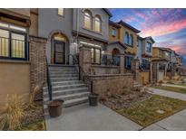 Inviting two-story home with brick accents, front patio and landscaped entryway at 15618 W Baker Ave, Lakewood, CO 80228