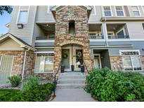 Inviting condo entrance featuring a stone facade, steps leading to the front door, and well-maintained landscaping at 474 Black Feather Loop # 419, Castle Rock, CO 80104