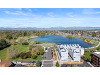 Stunning aerial view of the property overlooking a serene lake with mountain views in the distance on a sunny day at 3101 W 47Th Ave # 13, Denver, CO 80211