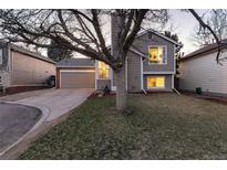 Charming home boasts a well-maintained exterior with a spacious driveway, lush lawn, and attached garage at 9333 Cattail Ct, Highlands Ranch, CO 80126