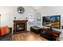 Cozy living room features a brick fireplace and bright windows, creating a warm and inviting space at 9333 Cattail Ct, Highlands Ranch, CO 80126