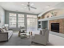 Comfortable living room featuring a fireplace and large windows for ample natural light at 9818 E Carolina Pl, Aurora, CO 80247