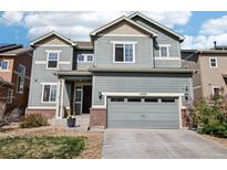 Charming two-story home featuring a well-maintained lawn, two-car garage and appealing curb appeal at 12233 Hannibal St, Commerce City, CO 80603