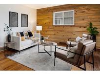 Charming living room features hardwood accent wall, modern furniture, and neutral rug at 4230 S Lipan St, Englewood, CO 80110