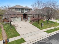 Beautiful two-story home with a three-car garage, brick accents, and mature trees enhancing the curb appeal at 13250 Wild Basin Way, Broomfield, CO 80020