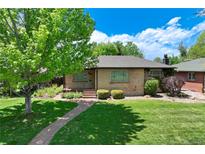 Charming brick home with mature tree, lush lawn, and quaint brick walkway at 3245 S High St, Englewood, CO 80113