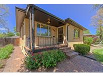 Charming brick home featuring a landscaped front yard and covered porch entry, perfect for relaxing outdoors at 3245 S High St, Englewood, CO 80113