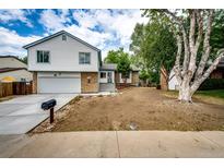 Charming home with a well-manicured lawn, long driveway, and inviting curb appeal on a partly cloudy day at 3679 S Zeno Way, Aurora, CO 80013