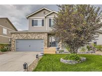 Charming two-story home with a brick facade, well-maintained lawn, and mature landscaping at 26072 E Fremont Pl, Aurora, CO 80016