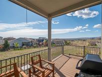 Relaxing back porch featuring a gas grill, wooden chairs, and sweeping mountain views at 16406 W 85Th Ln # A, Arvada, CO 80007