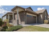 Beautiful stone clad exterior and attached two car garage of modern home with manicured lawn at 16406 W 85Th Ln # A, Arvada, CO 80007