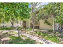 Charming condo exterior with lush landscaping, mature trees, and inviting walking paths at 4070 S Atchison Way # 101, Aurora, CO 80014