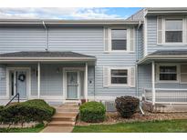 Charming townhome with light blue siding, white shutters, and a welcoming front porch at 6240 Everett Ct # D, Arvada, CO 80004