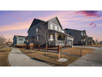 Two-story home with gray siding, a covered porch, and a two-car garage at 13267 E 108Th Ave, Commerce City, CO 80022