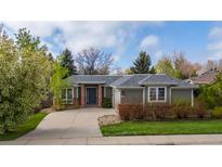Charming single-story home featuring a well-manicured lawn, mature trees, and a welcoming front entrance at 2330 Sandpiper Dr, Lafayette, CO 80026