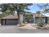 Charming home exterior with stone pathway and mature landscaping featuring a beautiful tree at 23785 Currant Dr, Golden, CO 80401