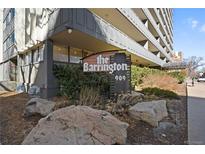 Exterior shot showcasing 'The Barrington' sign with stone landscaping in front of the building at 909 N Logan St # 10C, Denver, CO 80203