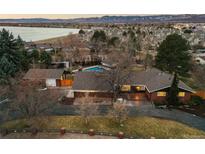 An aerial view of the home and property with a lake and distant mountains at 7382 W Stanford Ave, Littleton, CO 80123