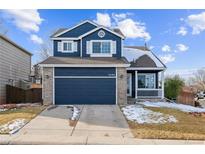 Beautiful two-story home with a navy blue exterior, a two-car garage, and a well-maintained lawn at 9790 Moss Rose Cir, Highlands Ranch, CO 80129