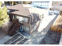 Two story brick building showing front stairway and small balcony and parking area at 2241 Dexter Dr # 2, Longmont, CO 80501