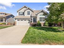 Charming two-story home with a well-maintained lawn and a two-car garage on a sunny day at 9294 Melborne Ct, Parker, CO 80134
