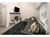 Inviting living room featuring a brick fireplace and a comfortable, modern black sectional sofa at 7978 Chase Cir # E, Arvada, CO 80003