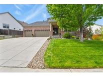 Charming brick home featuring an expansive driveway and a well-manicured lawn with mature landscaping at 1762 Granger Cir, Castle Rock, CO 80109