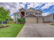 Charming two-story home with a three-car garage, stone accents, and well-manicured front yard at 4864 Harness Ct, Parker, CO 80134