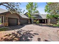 Charming home with a three car garage, a driveway, and stone details at 1570 Blakcomb Ct, Evergreen, CO 80439