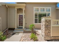 Inviting home exterior featuring a well-maintained front yard, a charming entrance, and stone accents at 9522 Silver Spur Ln, Highlands Ranch, CO 80130