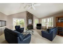Cozy living room with stone fireplace, vaulted ceiling, and access to outdoor space at 6468 S Hudson St, Centennial, CO 80121