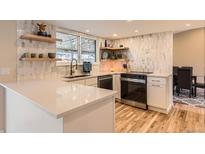 Bright kitchen featuring quartz countertops, white cabinetry, and stylish backsplash and flooring at 805 Northridge Rd, Highlands Ranch, CO 80126