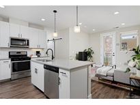 Modern kitchen with white cabinetry, stainless steel appliances, and an island with bar seating at 2729 W 28Th Ave # 302, Denver, CO 80211