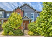 Charming townhome featuring a brick facade, gray siding, and well-maintained landscaping at 4885 S Algonquian Way, Aurora, CO 80016