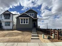 Charming two-story home with a gray exterior, white trim, and well-maintained landscaping at 2025 Barnwood Dr, Brighton, CO 80601