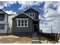 Charming two-story home with gray siding, white trim, and a welcoming front porch under a cloudy blue sky at 2025 Barnwood Dr, Brighton, CO 80601