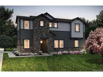 Charming two-story home with stone accents, gray siding, professional landscaping, and a well-manicured lawn at 23970 E 41St Ave, Aurora, CO 80019